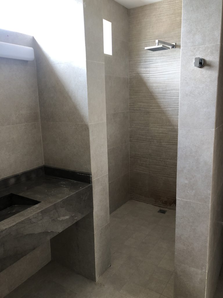 Baño en proceso de remodelación con regadera y cubierta